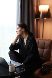 a woman sitting in a chair looking out a window